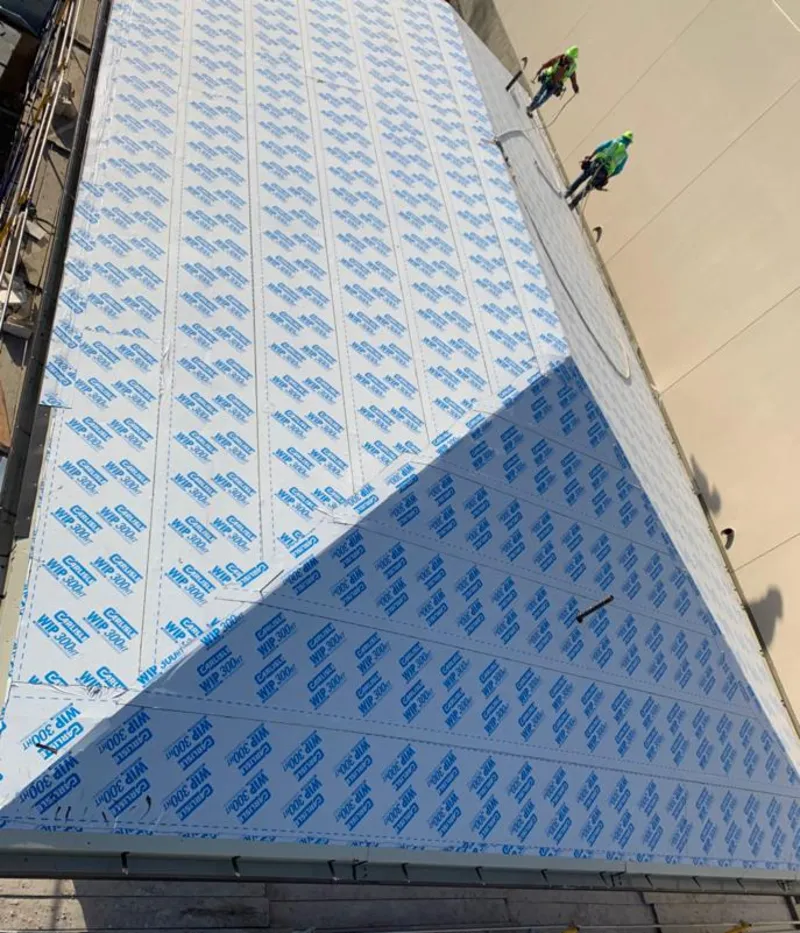 Professional roofers installing underlayment on a metal roof in Pueblo